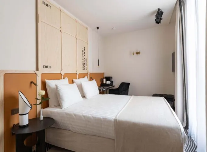 Chambre Double Terrasse Daniel Auteuil avec un lit et une tête de lit en bois à l’hôtel Astra Opéra