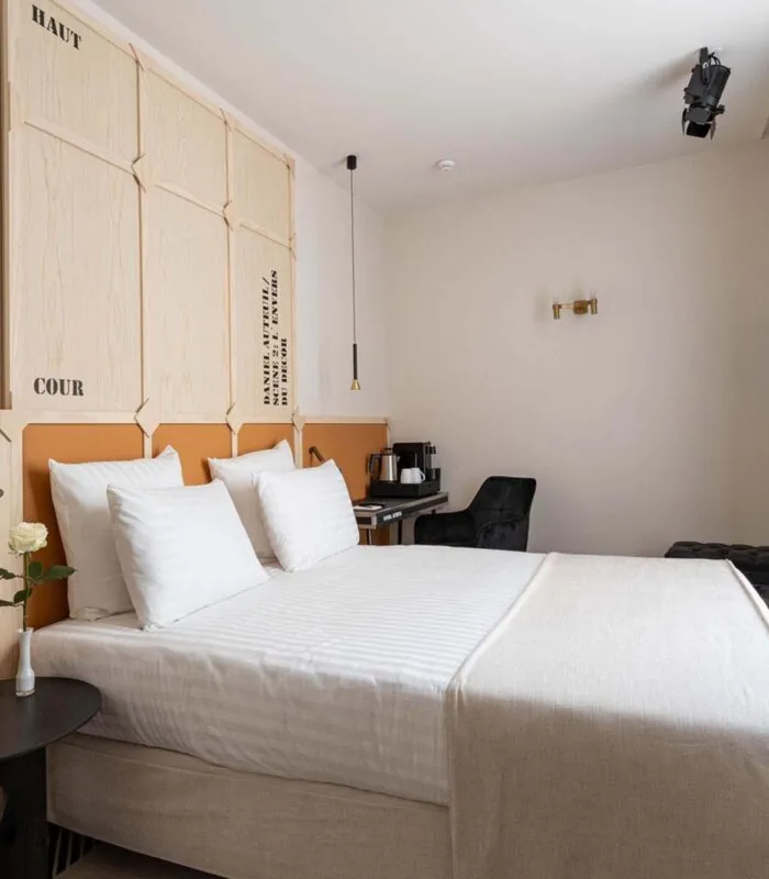 Chambre Double Terrasse Daniel Auteuil avec un lit et une tête de lit en bois à l’hôtel Astra Opéra