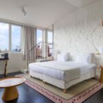 Vue du lit king size dans une chambre Privilège avec terrasse Marie-Agnès Gillot à l’hôtel Opera Astra