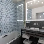 Vue de la salle de bains d’une chambre Double Supérieure Claudie Haigneré à l’hôtel Opera Astra