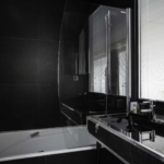 Vue de la salle de bain de la Chambre Familiale Double Privilège avec balcon à l’Hôtel Le 123 Sébastopol avec baignoire et lavabo