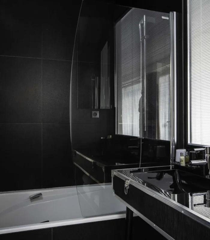Vue de la salle de bain de la Chambre Familiale Double Privilège avec balcon à l’Hôtel Le 123 Sébastopol avec baignoire et lavabo