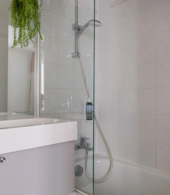 Badezimmer des Doppelzimmers mit einem Waschbecken, einer Badewanne mit Dusche und einem Spiegel im Hotel George
