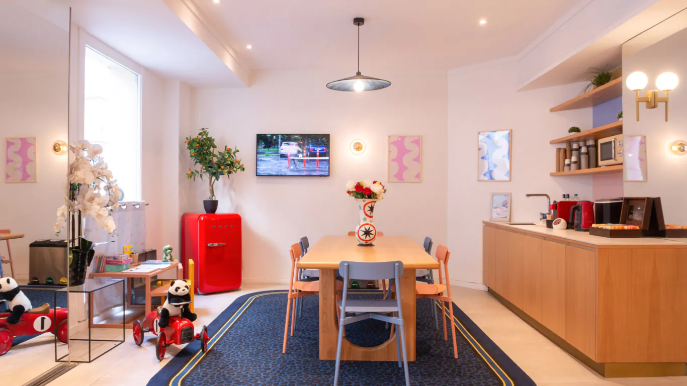 Hall d'accueil de l'hôtel 3 étoiles Acadia à Paris avec des couleurs élégantes et un espace pour enfants.