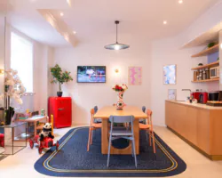 Hall d'accueil de l'hôtel 3 étoiles Acadia à Paris avec des couleurs élégantes et un espace pour enfants.