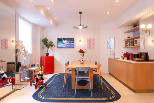 Hall d'accueil de l'hôtel 3 étoiles Acadia à Paris avec des couleurs élégantes et un espace pour enfants.
