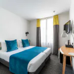Twin-Zimmer im Hotel George mit zwei Betten und einem Schreibtisch
