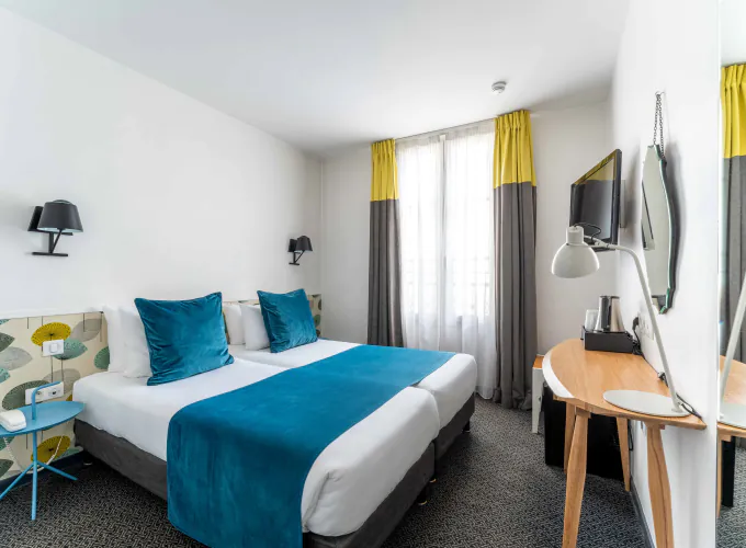 Twin-Zimmer im Hotel George mit zwei Betten und einem Schreibtisch