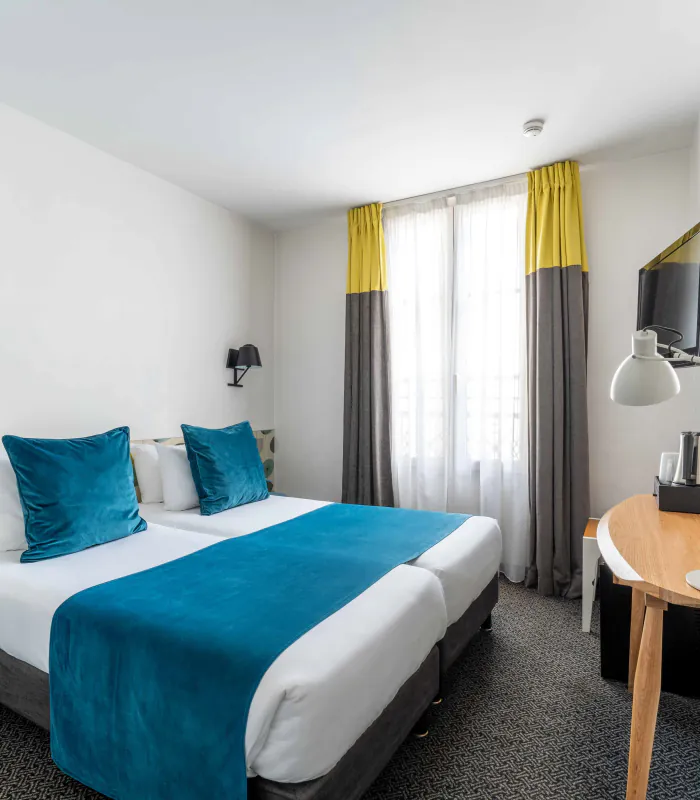 Twin-Zimmer im Hotel George mit zwei Betten und einem Schreibtisch