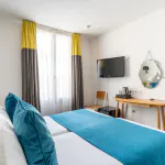 Twin-Zimmer im Hotel George mit zwei Betten und einem Schreibtisch