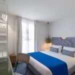 Chambre double avec tête de lit à rayures bleues et blanches à l’Hôtel 34B