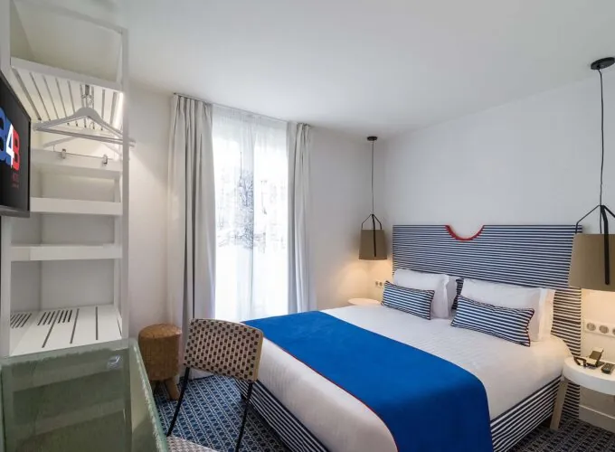 Chambre double avec tête de lit à rayures bleues et blanches à l’Hôtel 34B