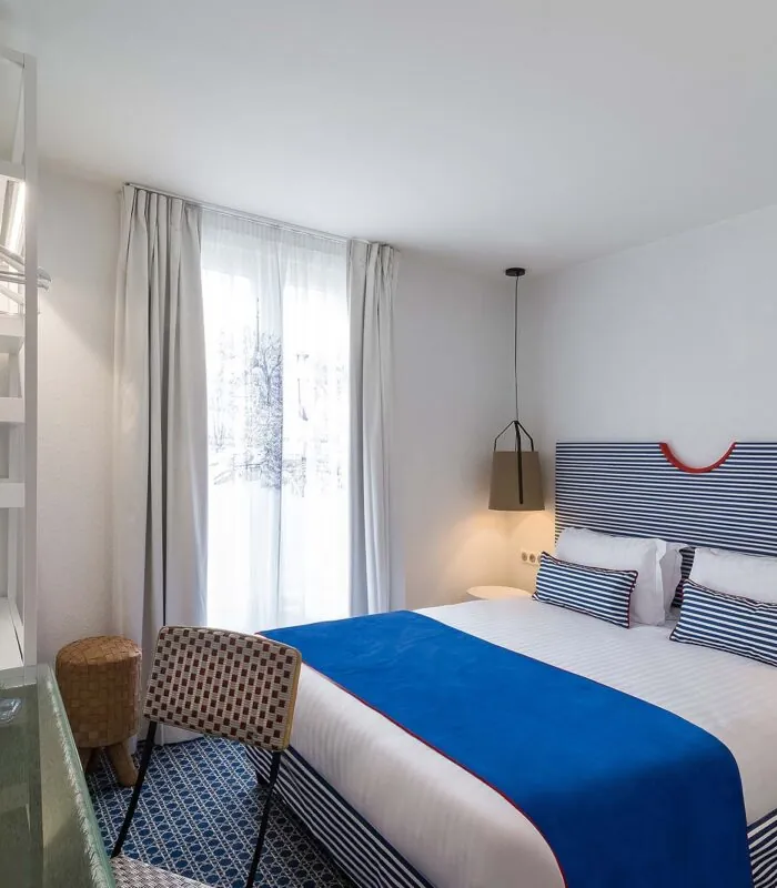 Chambre double avec tête de lit à rayures bleues et blanches à l’Hôtel 34B