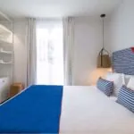 Chambre double avec tête de lit à rayures bleues et blanches à l’Hôtel 34B