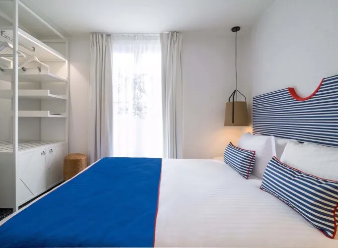 Chambre double avec tête de lit à rayures bleues et blanches à l’Hôtel 34B