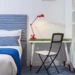 Chambre double avec un lit et un bureau avec une lampe rouge à l’Hôtel 34B