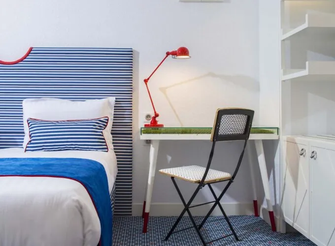 Chambre double avec un lit et un bureau avec une lampe rouge à l’Hôtel 34B