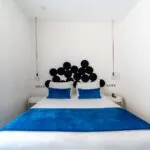 Chambre Double Supérieure avec un lit, une couverture bleue et des oreillers bleus à l’Hôtel 34B