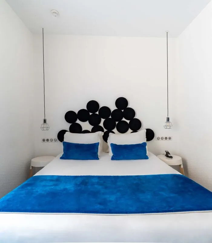 Chambre Double Supérieure avec un lit, une couverture bleue et des oreillers bleus à l’Hôtel 34B