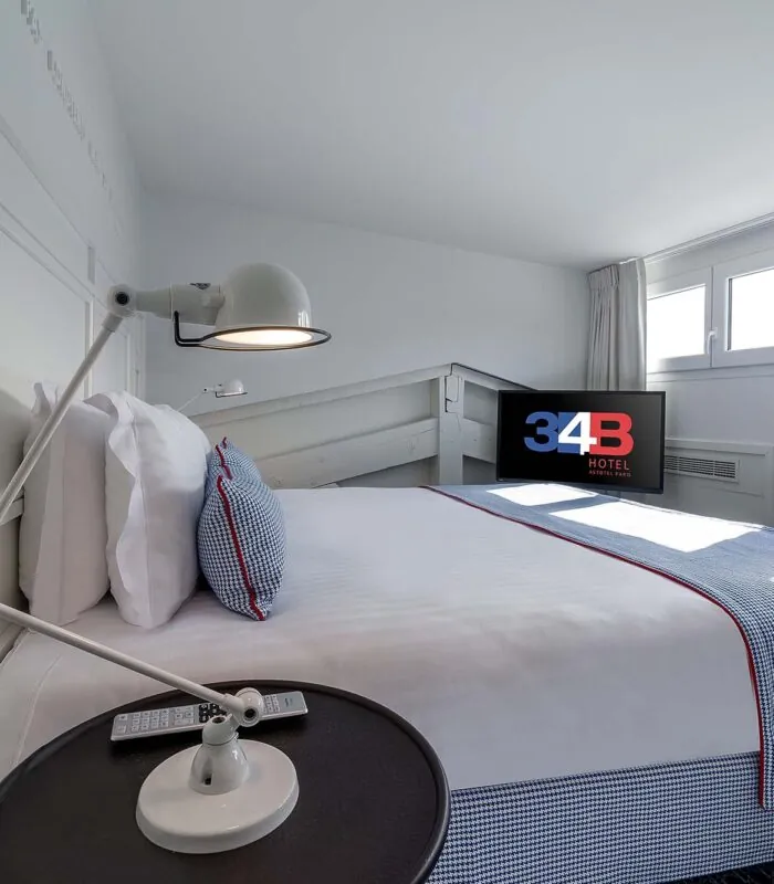 Chambre Duplex avec un lit et une télévision à l’Hôtel 34B