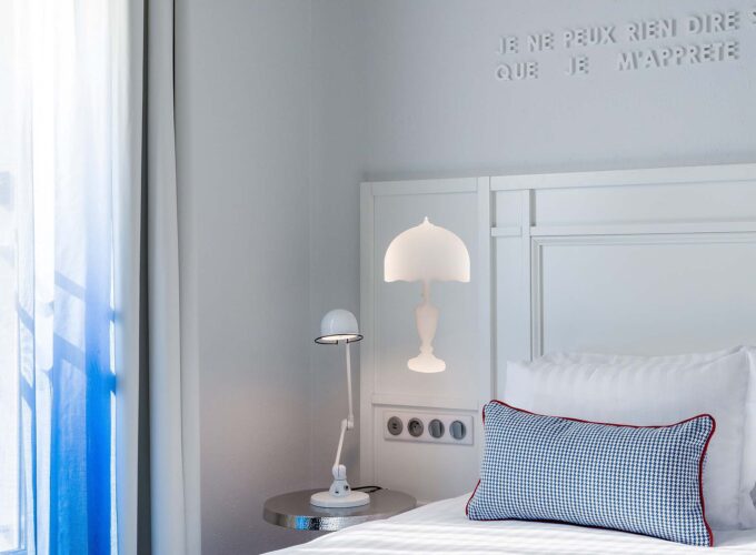 Chambre Duplex avec un lit, une lampe et une enseigne sur le mur à l’Hôtel 34B