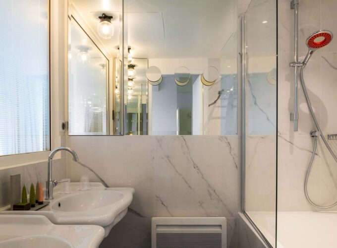 Salle de bain de la Chambre Duplex avec deux lavabos et une douchette rouge à l’Hôtel 34B