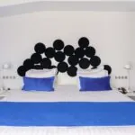 Chambre Familiale avec lit doté d’oreillers bleus et d’une tête de lit noire à l’Hôtel 34B