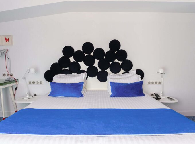 Chambre Familiale avec lit doté d’oreillers bleus et d’une tête de lit noire à l’Hôtel 34B