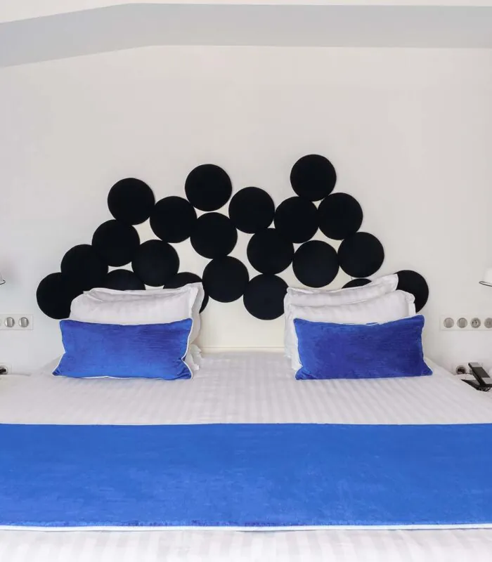 Chambre Familiale avec lit doté d’oreillers bleus et d’une tête de lit noire à l’Hôtel 34B