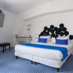 Chambre Familiale avec un lit et un bureau à l’Hôtel 34B