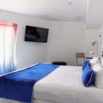 Chambre Familiale avec un lit king size et une télévision à écran plat à l’Hôtel 34B