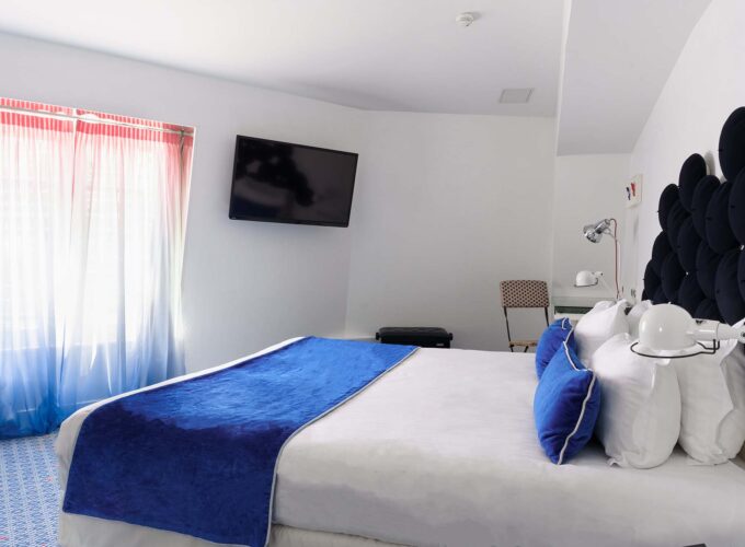 Chambre Familiale avec un lit king size et une télévision à écran plat à l’Hôtel 34B