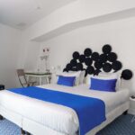 Chambre familiale avec une couverture bleue sur le lit à l’Hôtel 34B