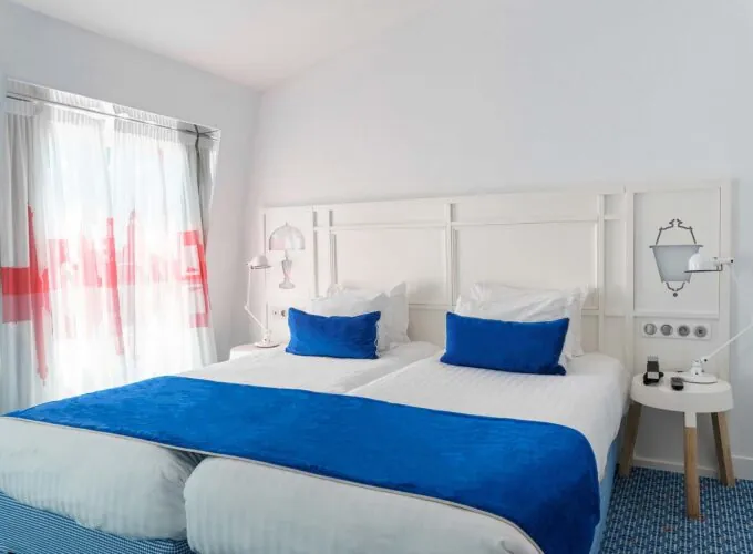 Chambre Familiale avec deux lits et des oreillers bleus à l’Hôtel 34B