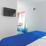 Chambre Familiale avec deux lits et une télévision à écran plat à l’Hôtel 34B