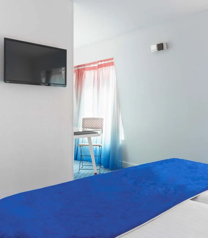 Chambre Familiale avec deux lits et une télévision à écran plat à l’Hôtel 34B