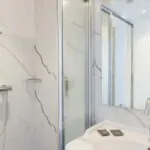 Salle de bain de la Chambre Familiale avec un lavabo, une douche et un miroir à l’Hôtel 34B