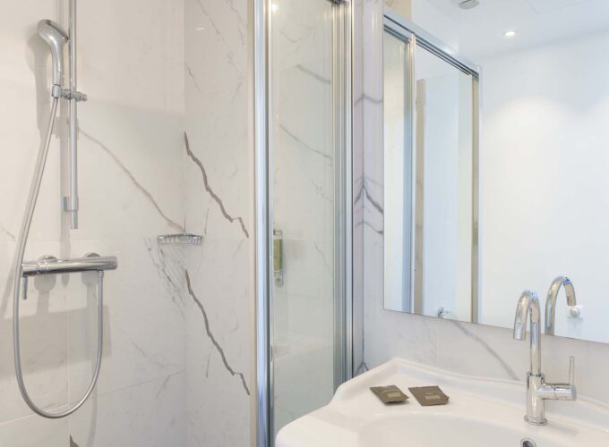 Salle de bain de la Chambre Familiale avec un lavabo, une douche et un miroir à l’Hôtel 34B