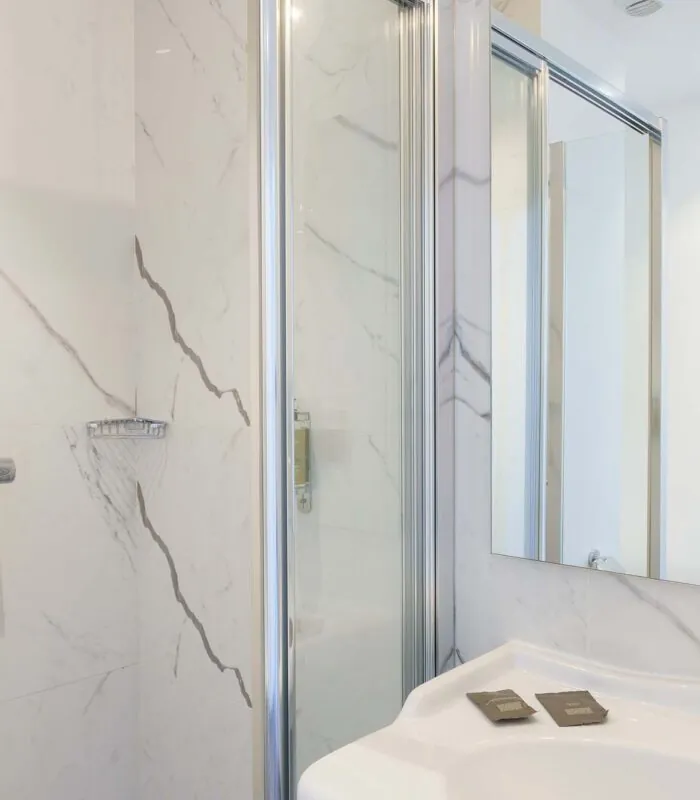 Salle de bain de la Chambre Familiale avec un lavabo, une douche et un miroir à l’Hôtel 34B
