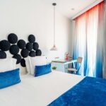 Chambre Familiale Supérieure avec un lit et un bureau sur lequel se trouve un livre à l’Hôtel 34B