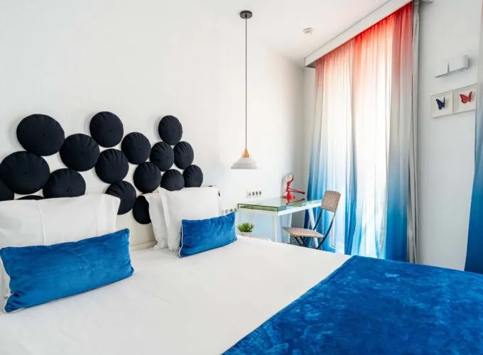 Chambre Familiale Supérieure avec un lit et un bureau sur lequel se trouve un livre à l’Hôtel 34B