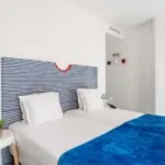 Chambre Familiale Supérieure avec une tête de lit rayée bleue et blanche à l’Hôtel 34B