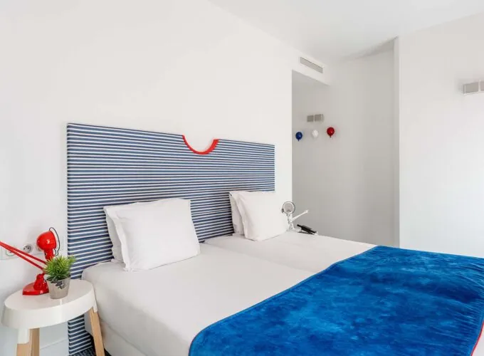 Chambre Familiale Supérieure avec une tête de lit rayée bleue et blanche à l’Hôtel 34B