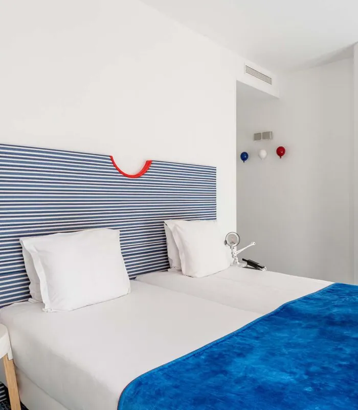 Chambre Familiale Supérieure avec une tête de lit rayée bleue et blanche à l’Hôtel 34B