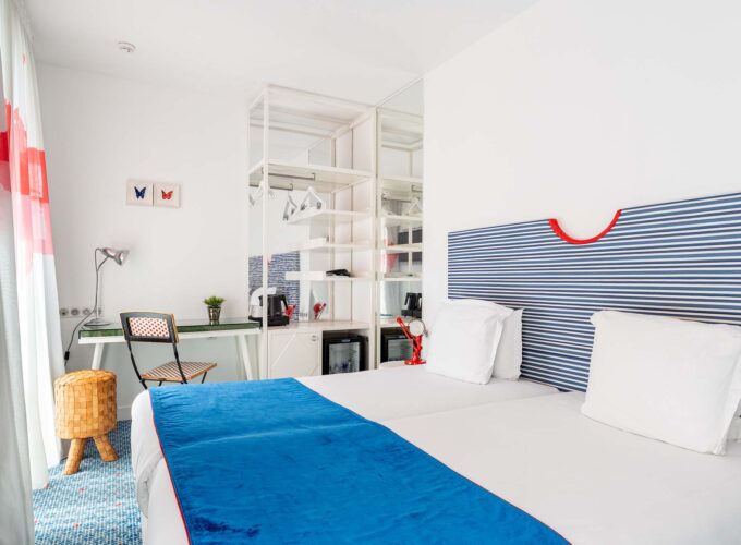 Chambre Familiale Supérieure avec une tête de lit rayée bleue et blanche à l’Hôtel 34B