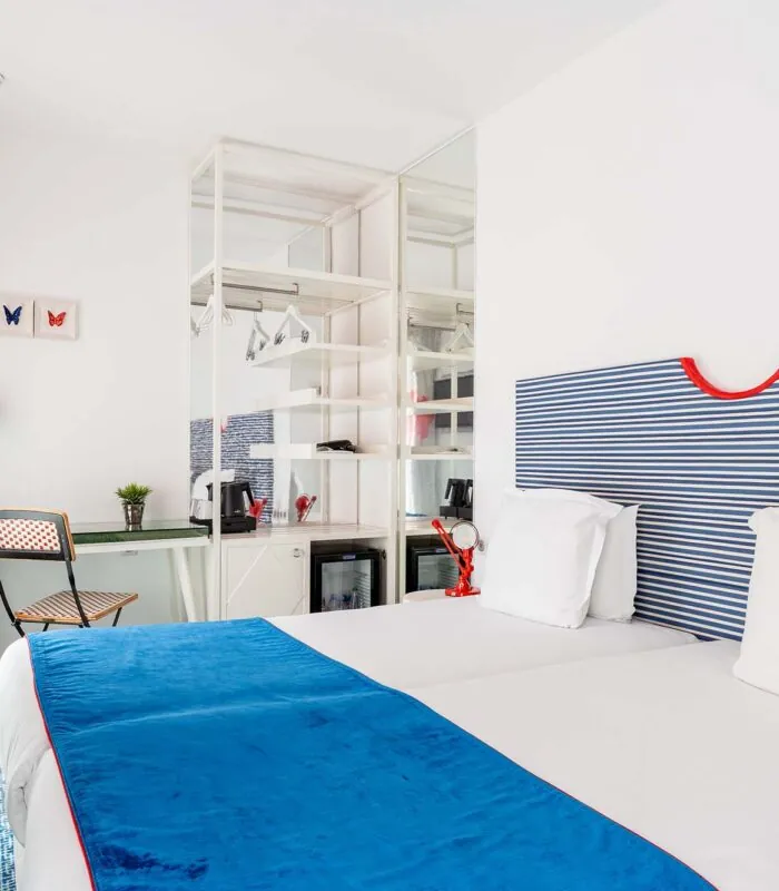 Chambre Familiale Supérieure avec une tête de lit rayée bleue et blanche à l’Hôtel 34B