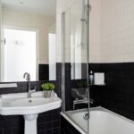 Salle de bain de la Chambre Familiale Supérieure avec des carreaux noirs et blancs et un lavabo à l’Hôtel 34B