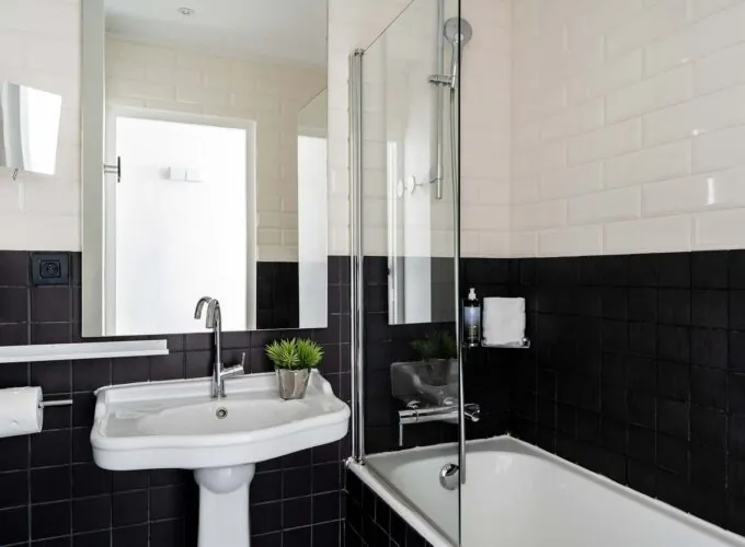 Salle de bain de la Chambre Familiale Supérieure avec des carreaux noirs et blancs et un lavabo à l’Hôtel 34B