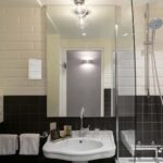 Salle de bain de la Chambre Privilège avec un lavabo, un miroir et une douche à l’Hôtel 34B