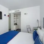 Chambre Single avec une tête de lit à rayures bleues et blanches à l’Hôtel 34B